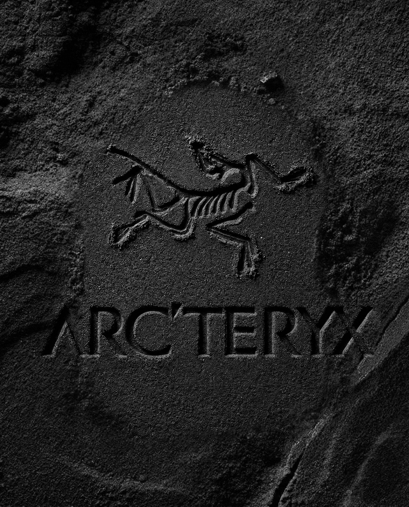 Logo Arc'teryx gravé dans la roche comme un fossile