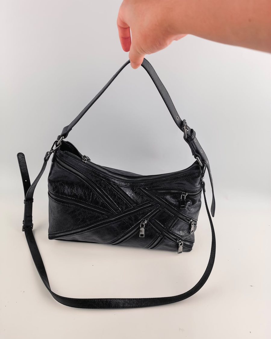 Photo du sac prise au téléphone par la cliente, tenu à la main sur fond gris