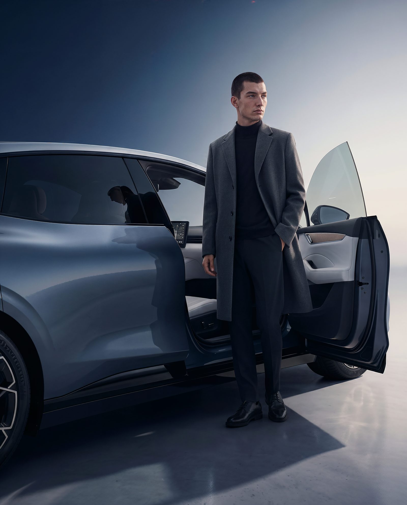 Homme en manteau sombre près de la Zeekr 007 portière ouverte